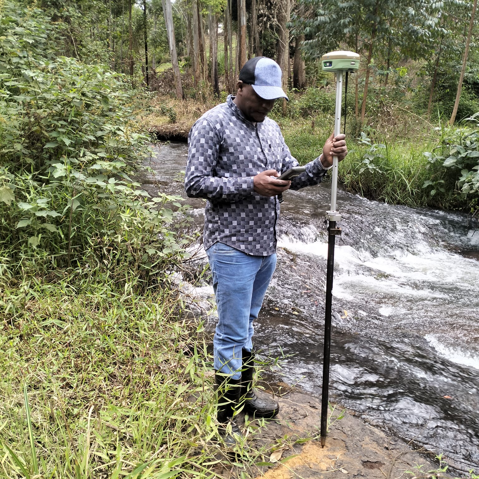 Erick Surveyors surveyor operating a GNSS rover and data controller in the field